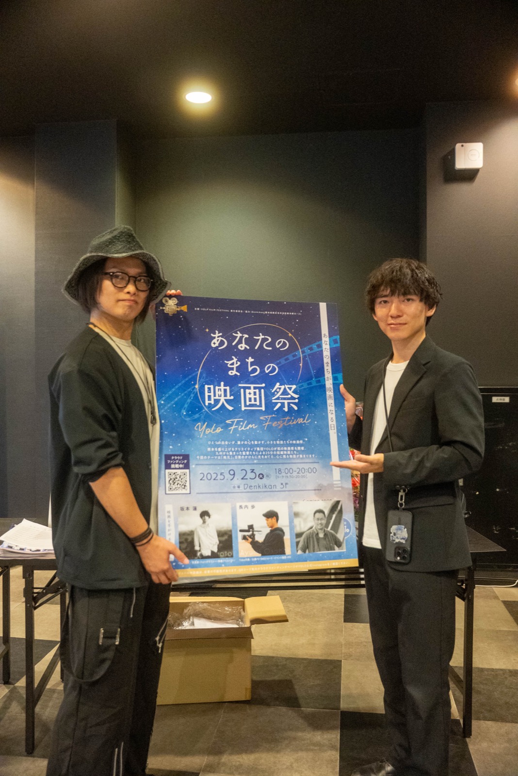 第1回のポスターを持つスタッフ